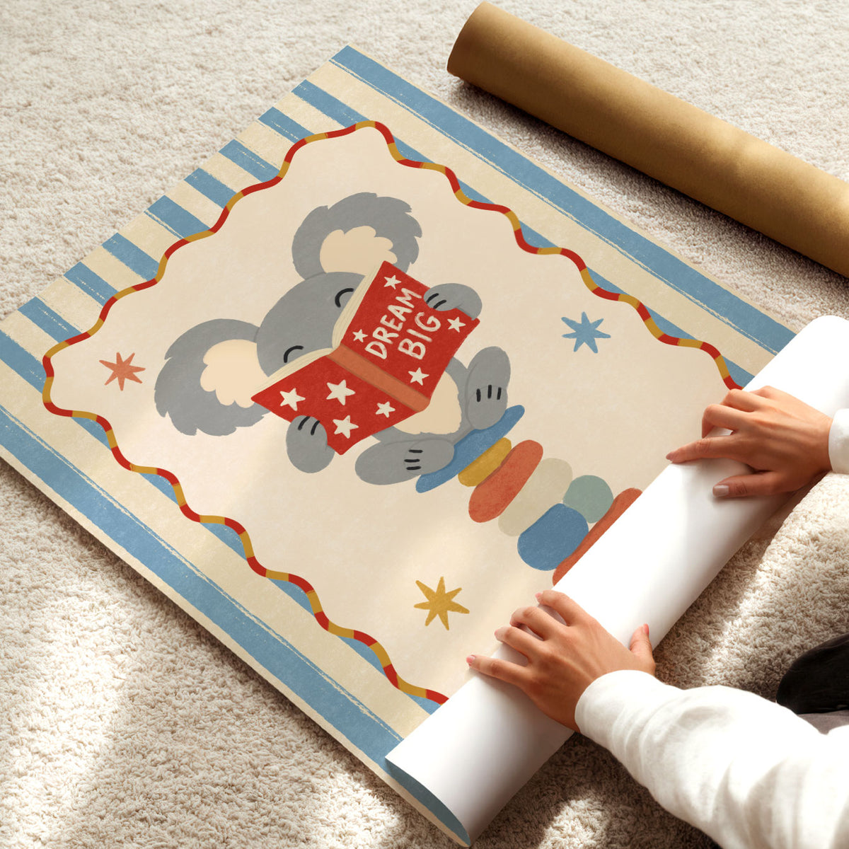 Illustrated poster of a koala on stacked stones reading a red book that says dream big