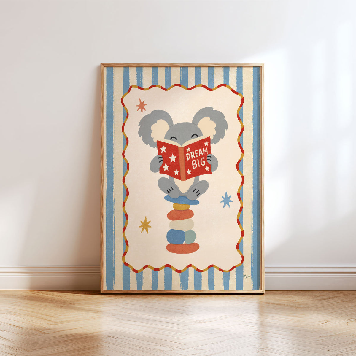 Illustrated poster of a koala on stacked stones reading a red book that says dream big