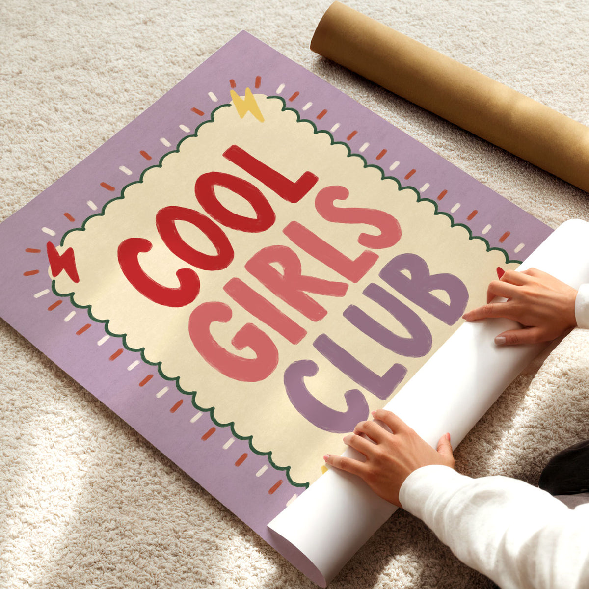 Bold hand-painted lettering reading Cool Girls Club in red, coral and lilac inside a scalloped green border on a lilac background.