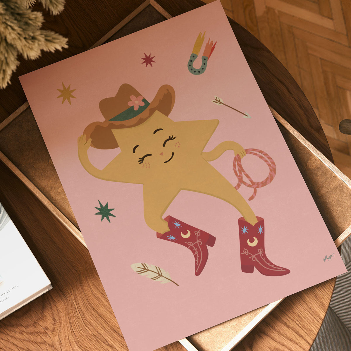 Illustrated yellow star with a face wearing a cowboy hat and red cowboy boots, holding a lasso, on a soft pink background.