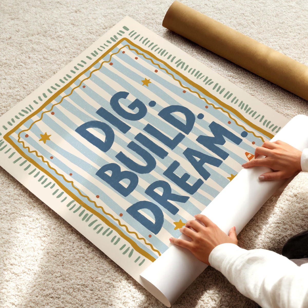 Illustrated poster with the hand lettered words dig build dream on blue stripes inside a gold frame
