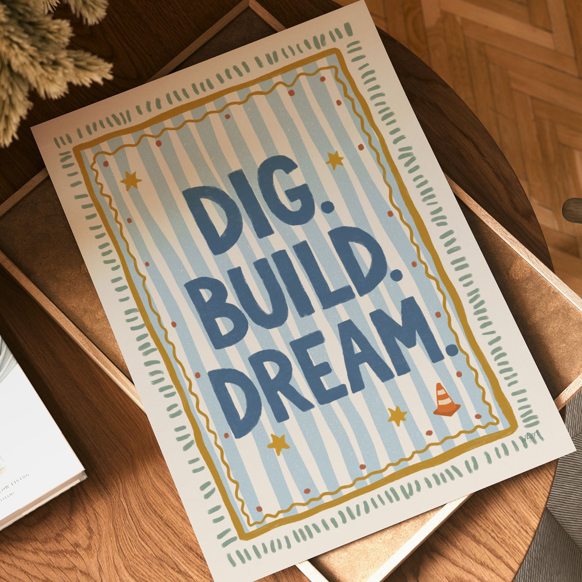 Illustrated poster with the hand lettered words dig build dream on blue stripes inside a gold frame