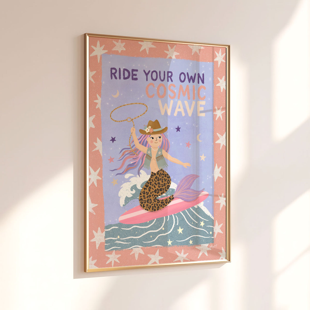 Illustrated poster of a cowgirl mermaid surfing a wave with a lasso under the words ride your own cosmic wave