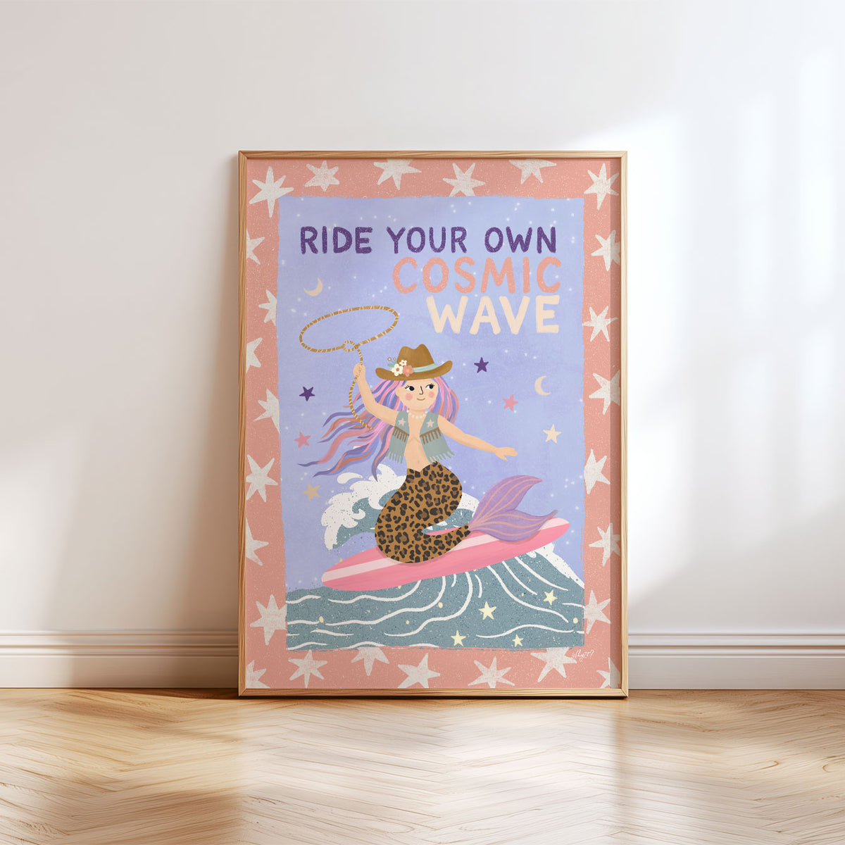 Illustrated poster of a cowgirl mermaid surfing a wave with a lasso under the words ride your own cosmic wave