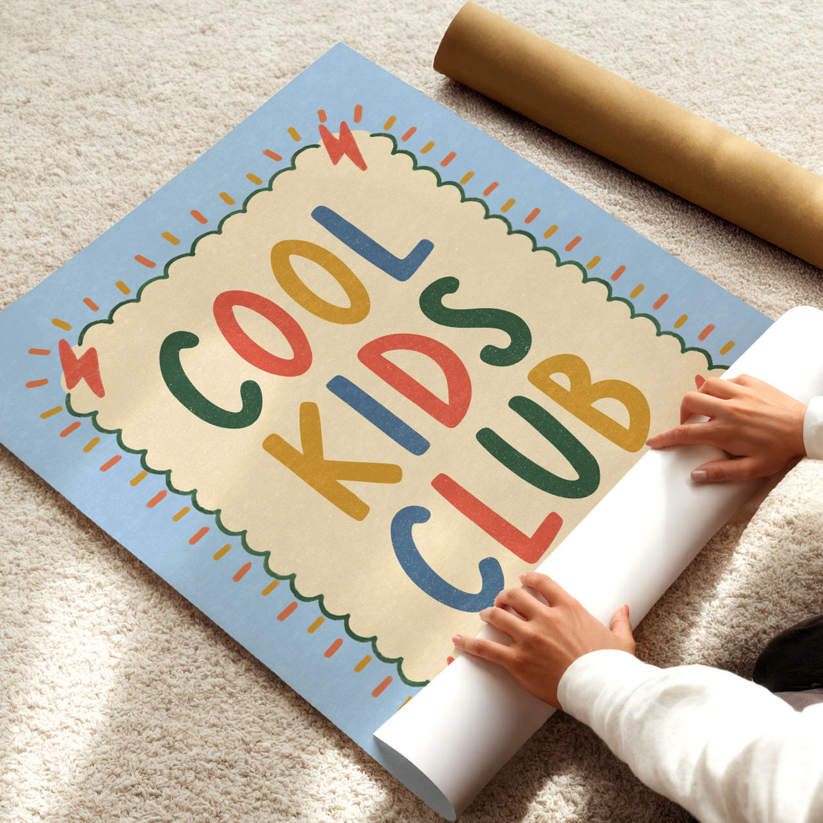 Illustrated poster with the hand lettered words cool kids club on a cream scalloped card