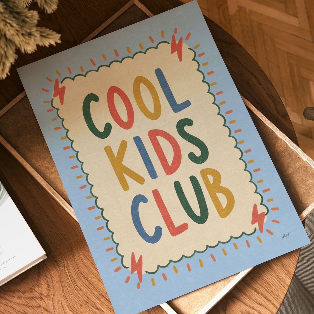 Illustrated poster with the hand lettered words cool kids club on a cream scalloped card