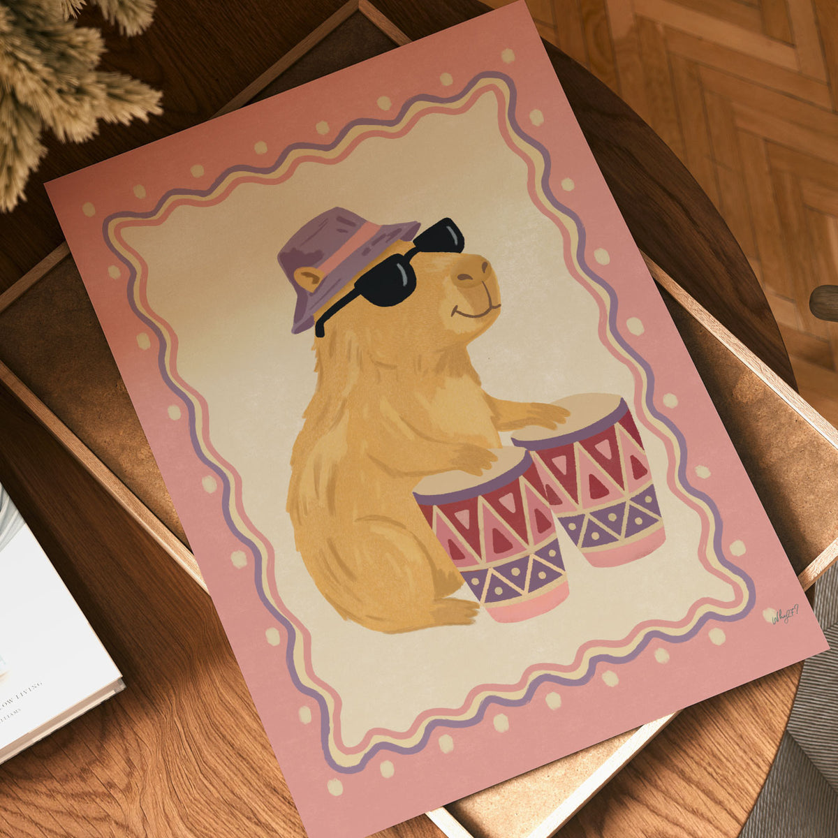 Illustrated capybara in sunglasses and a lilac bucket hat playing bongo drums, inside a wavy border on a dusty pink background.