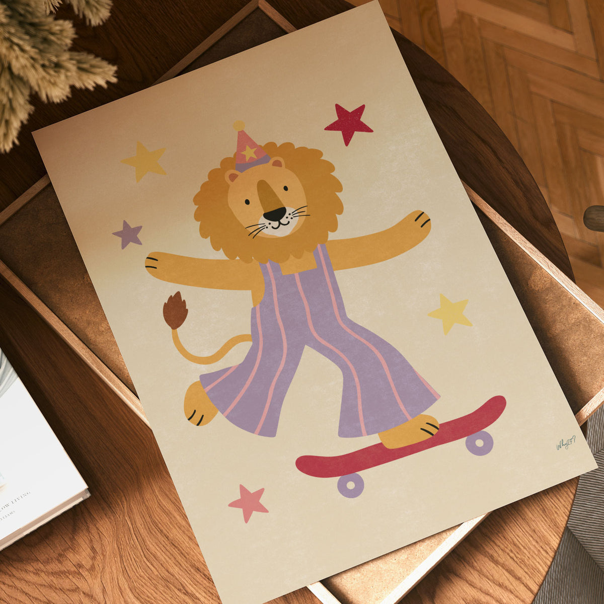 Illustrated lion wearing a party hat and lilac striped overalls riding a red skateboard surrounded by stars on a cream background.