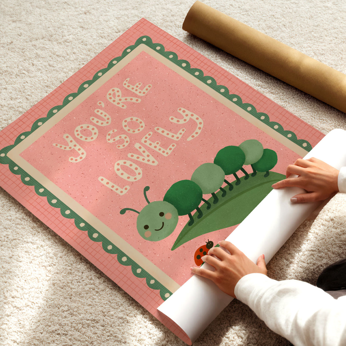 Hand-drawn caterpillar nursery poster with playful You’re So Lovely quote on a warm pink background.
