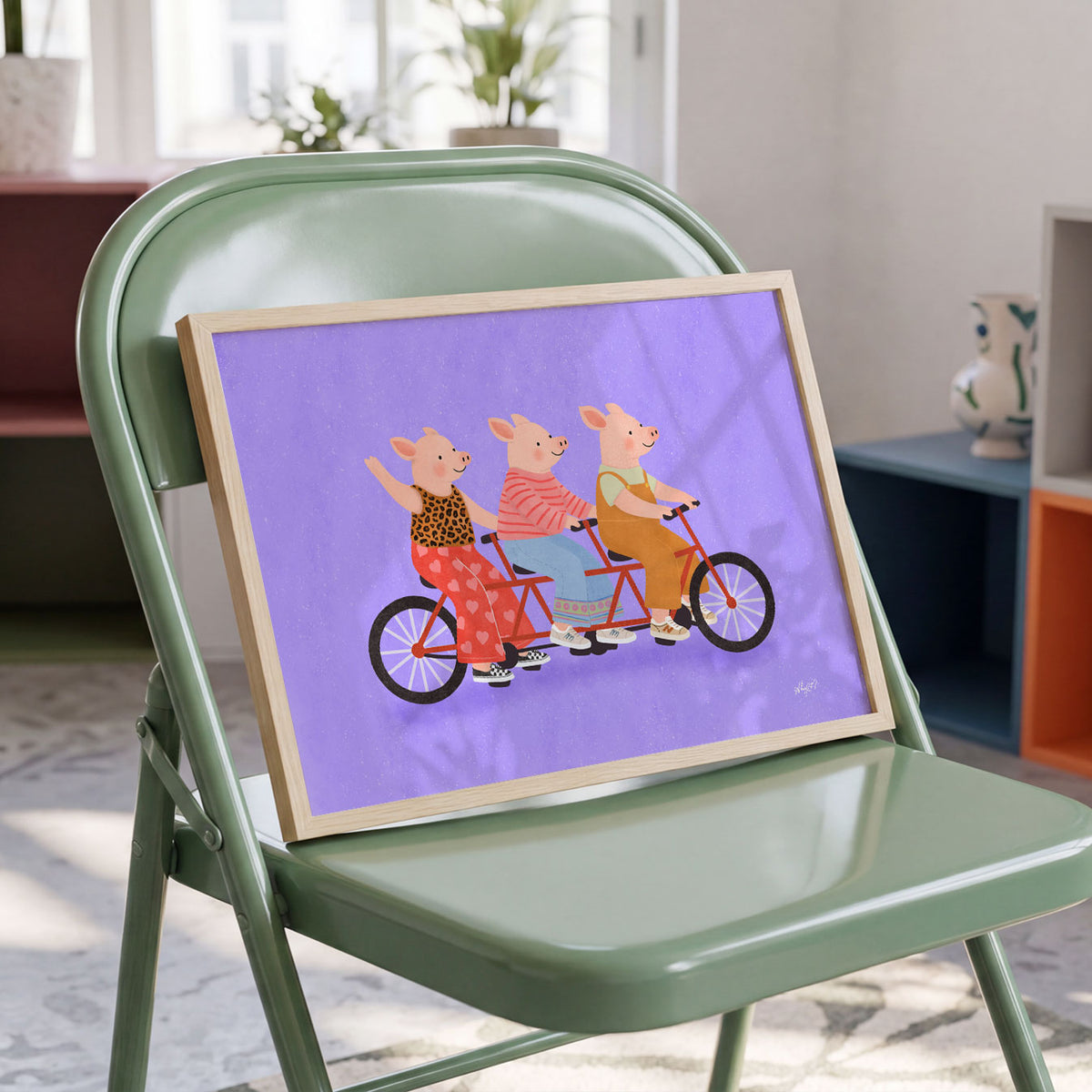 Landscape poster of three pigs riding a long red tandem bicycle on purple