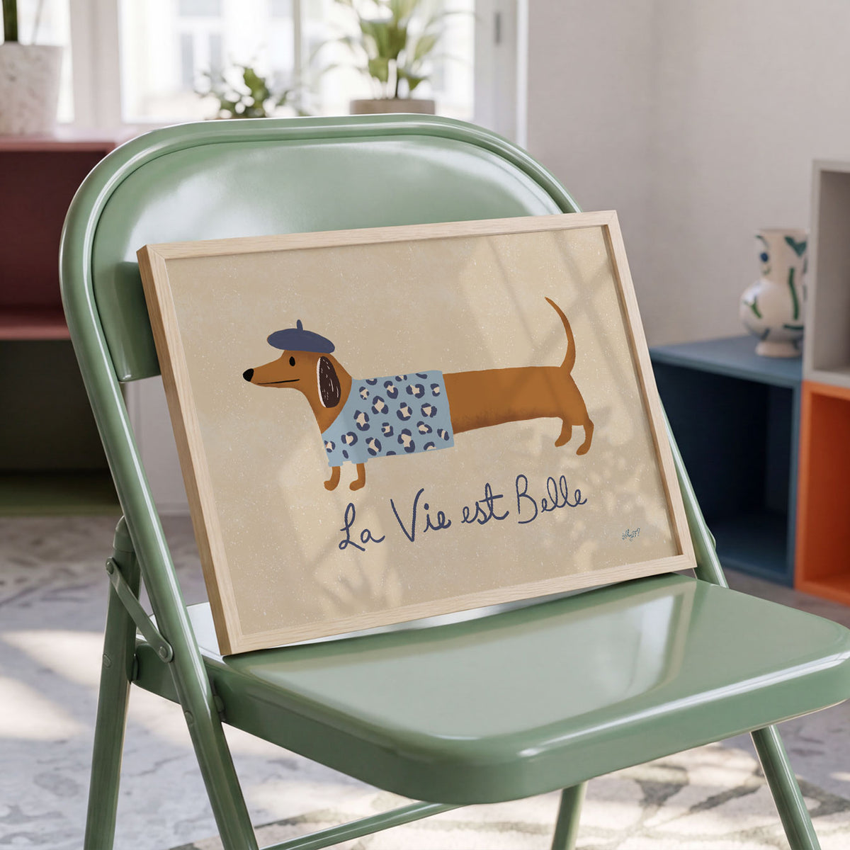 Landscape poster of a dachshund in a beret beside the words la vie est belle