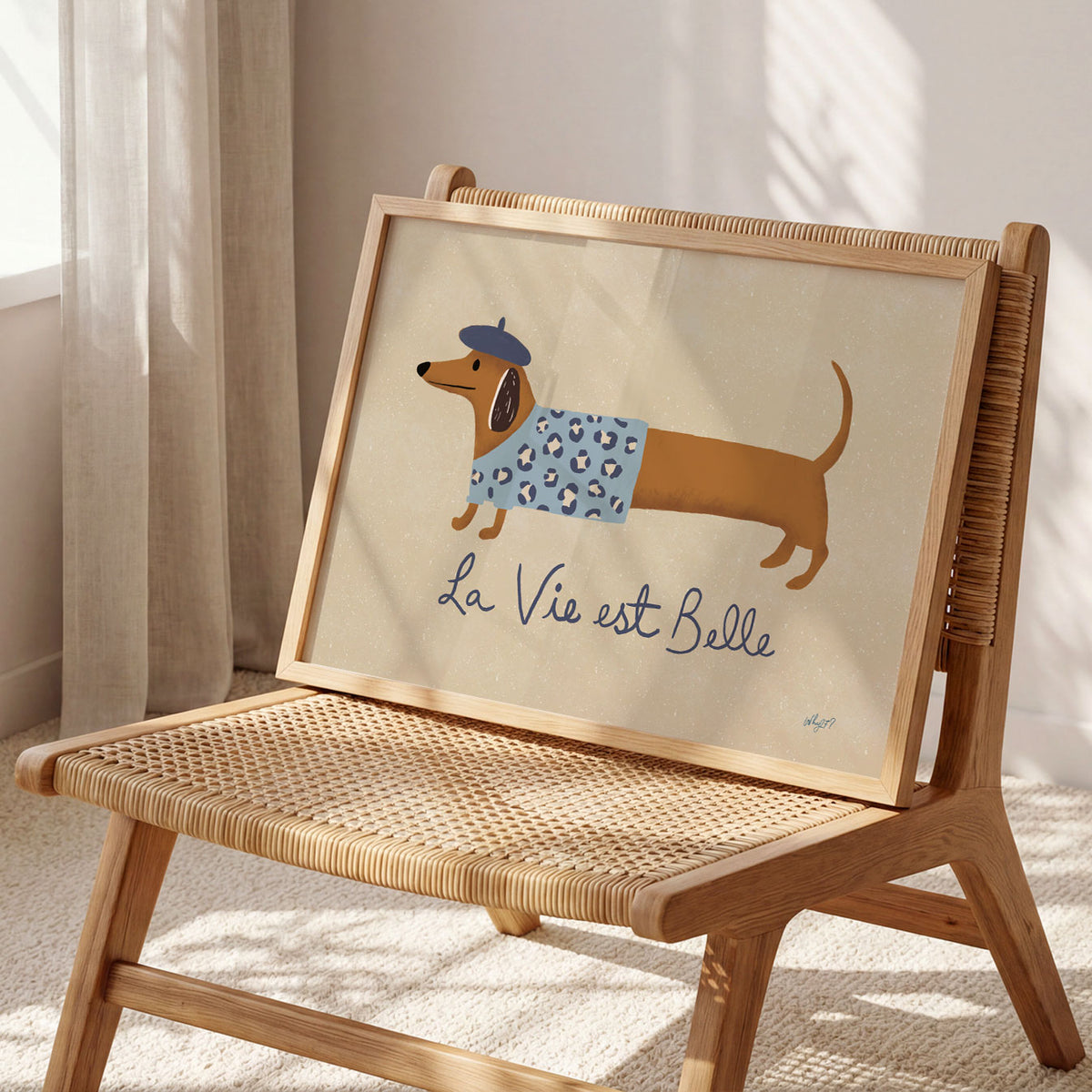 Landscape poster of a dachshund in a beret beside the words la vie est belle