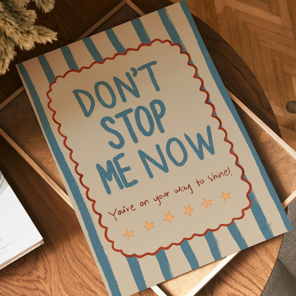 Positive typography print with bold blue Don’t Stop Me Now lettering, small stars and a hand-drawn scalloped border.